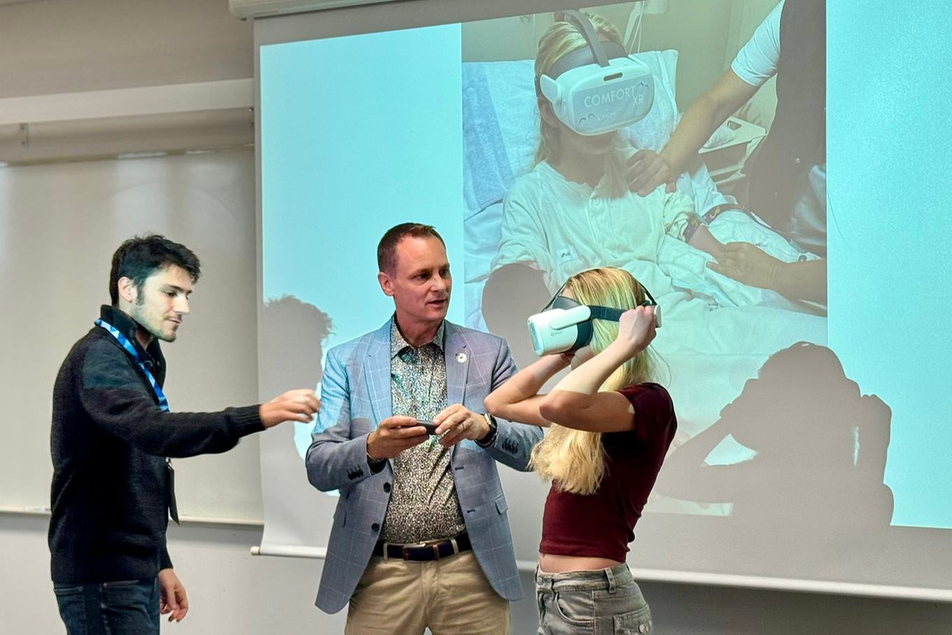 Tre personer som donar med ett VR-set. Bild. 